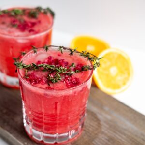 clear drinking glass with red liquid and sliced lemon